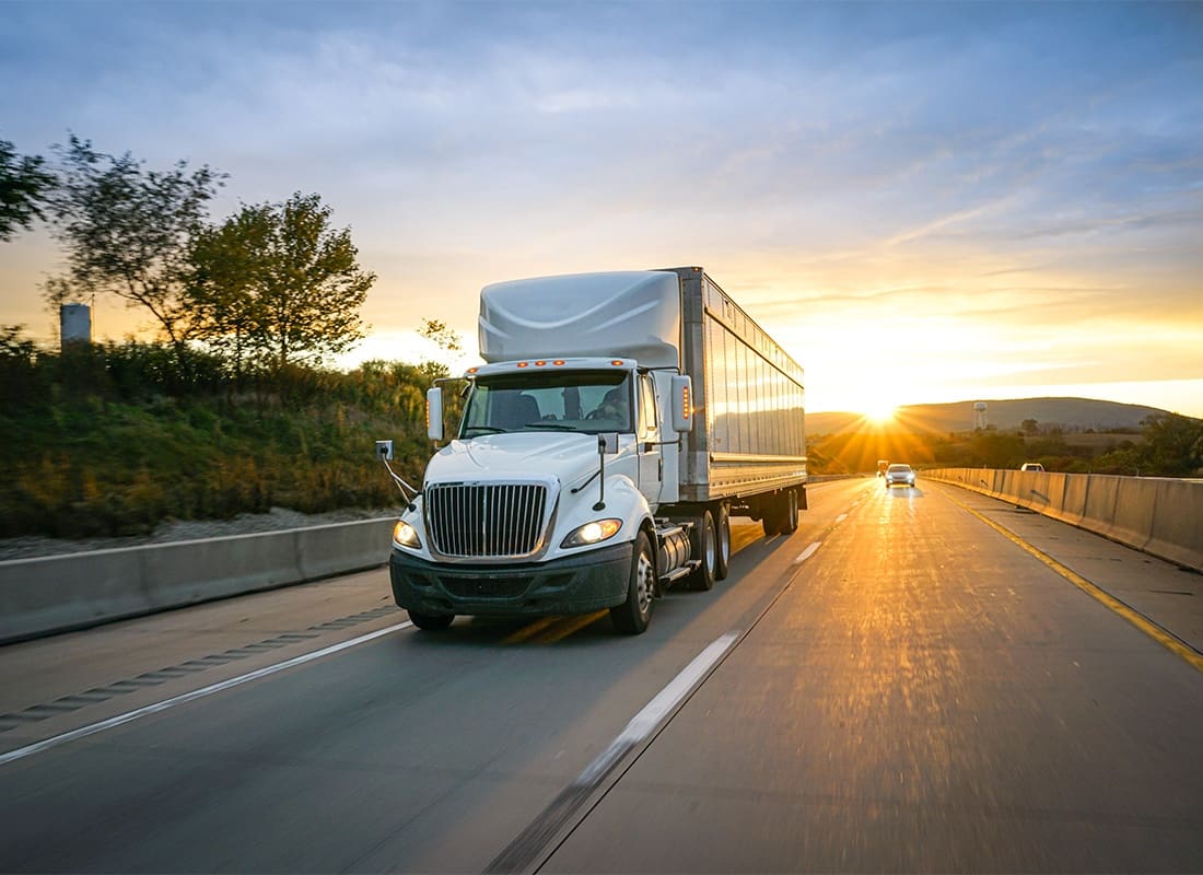 Business Insurance - White Semi-Truck on the Highway Delivering Freight