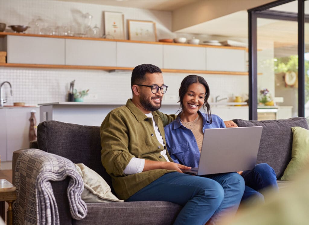We Are Independent - Young Couple Using Laptop at Home